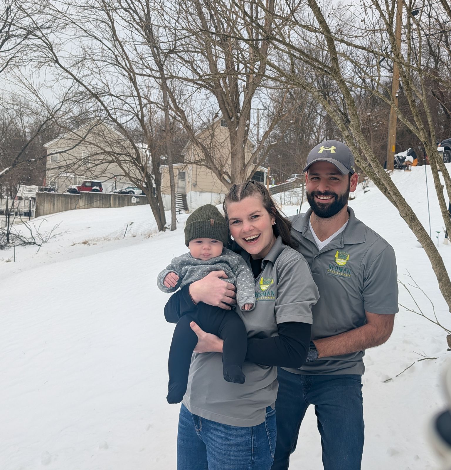 Lucas Redman with his wife and baby in the snow, wearing Redman Structures shirts
